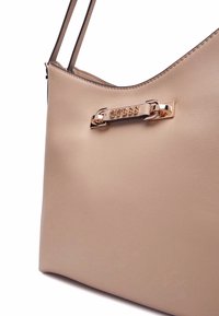 Borsa a spalla beige in materiale sintetico, con una texture liscia, forma curva e un'ornamentazione del logo in rosso oro metallizzato.