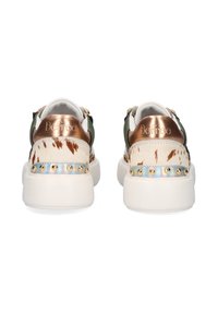 Un par de zapatillas deportivas blancas de plataforma con acentos en el talón de bronce, patrón de manchas marrones, tachuelas doradas en la franja reflectante y lados de tela verde, vista trasera.
