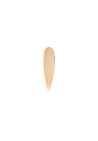 Kremet foundationformel i en glatt, avlang dråpeform; myk beige farge med matt finish; ingen synlig glans eller tekstur.