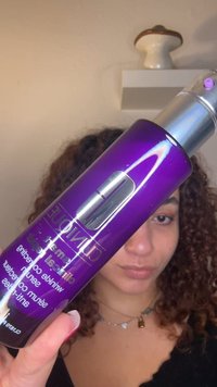 Lilla flaske med en sølvpumpe, merket "Clinique Smart", med en glanset finish og tekst som fremhever "rynke-korrigerende" og "serum."