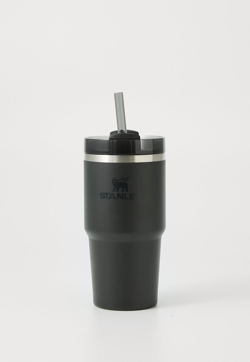 Stanley termos insulated keski matalassa mustassa värissä, jossa on läpinäkyvä kansi, silikonipilli ja hopea rengas. Sisältää "STANLEY"-logon.