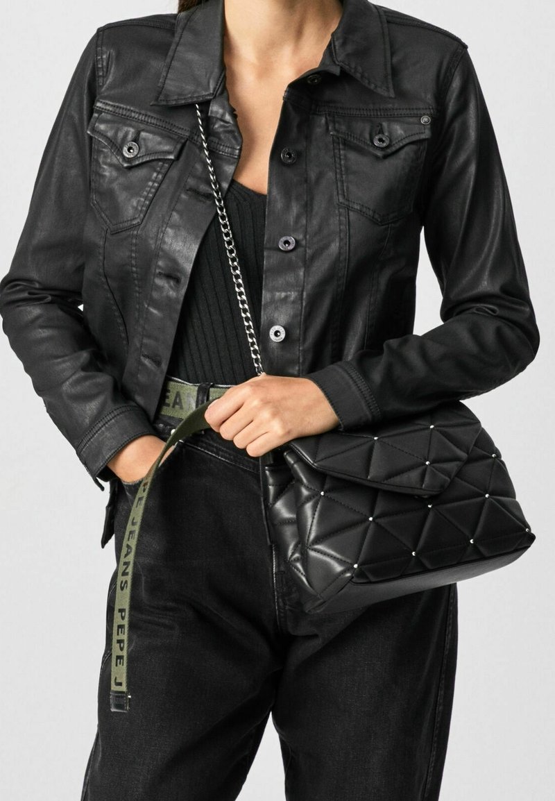 Schwarze, kunstlederne Jacke mit geknöpften Taschen, kombiniert mit einer schwarzen, gesteppte Handtasche mit silbernen Nieten und einer Kettenriemen.