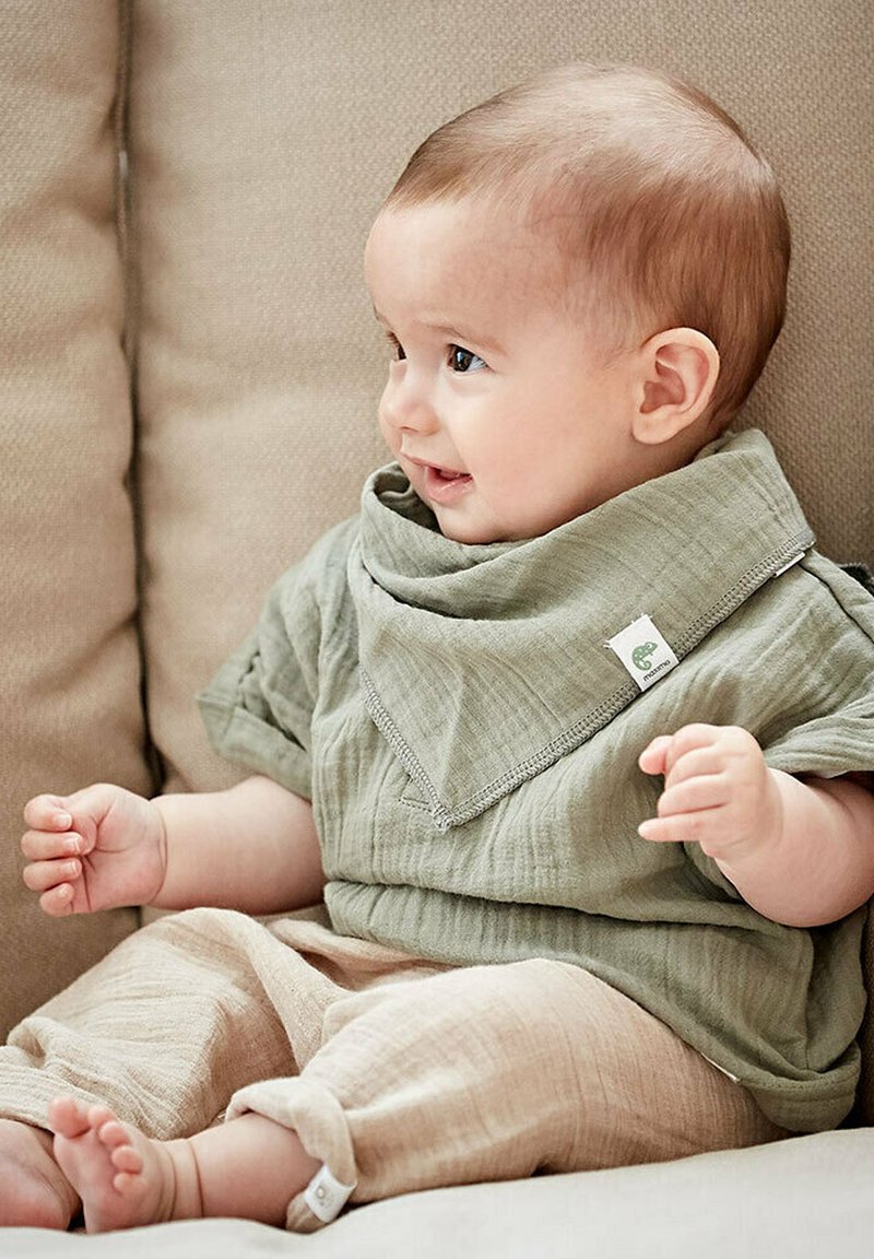 Helles grünes Baumwolloberteil mit großem Kragen und beigen Leinenhosen. Das Outfit verfügt über einen strukturierten Stoff und umgeschlagene Ärmel, geeignet für Säuglinge.