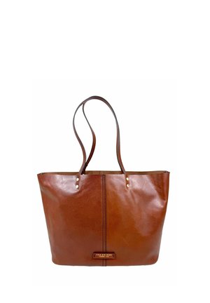 Borsa tote in pelle marrone con due manici e una piccola etichetta frontale con la scritta "The Bridge Firenze 1969" su sfondo bianco.