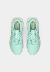 Jasnoniebieskie buty sportowe charakteryzują się siateczkową cholewką, okrągłym czubkiem, amortyzowaną podeszwą oraz płaskimi sznurówkami z subtelną teksturowaną powierzchnią i akcentami logo.