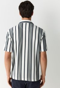 Overhemd met korte mouwen met verticale marineblauwe en witte strepen, gemaakt van een glad, gestructureerd stofje en met een klassieke kraag.