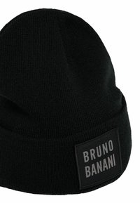 Svart stickad mössa med vikbar kant. Har en rektangulär etikett med vit text "BRUNO BANANI" på svart bakgrund. Mjuk textur.