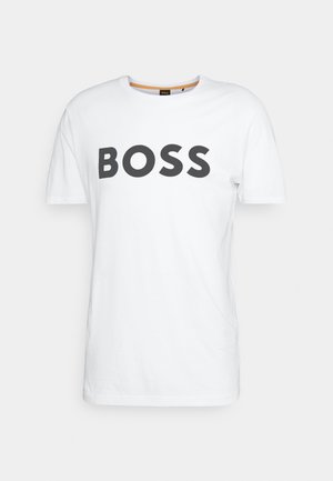 Vit bomulls T-shirt med korta ärmar, med ordet "BOSS" i fet svarts bokstäver över bröstet. Rund halsringning, enkel design.