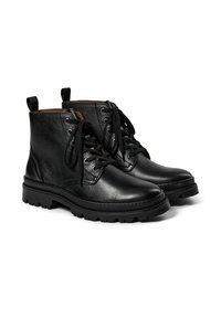 Botas de tobillo de cuero negro con punteras redondeadas, parte superior texturizada, cordones al frente y suelas gruesas y resistentes. Presenta lengüetas en la parte posterior.