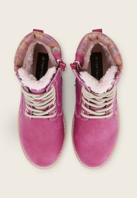 Bottines roses à lacets avec doublure en fourrure douce et poignets tricotés multicolores, conçues pour la chaleur et le confort.