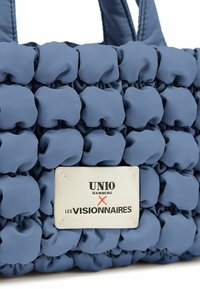 Borsa tote blu con texture, caratterizzata da un design imbottito, etichetta in tessuto con "UNIO" e "LES VISIONAIRES", e manici doppi.