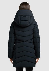Schwarze Daunenjacke mit einem Zickzackmuster, einer großen Kapuze und einem Reißverschluss. Weiches Material mit gestepptem Muster, bis zur Mitte des Oberschenkels.
