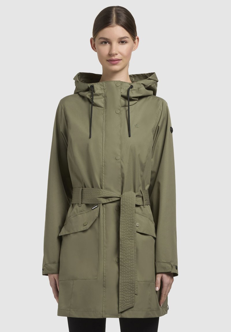 Olijfgroene waterdichte jas met een trekkoordcapuchon, een riem in de taille, twee voorzakken en een drukknoopsluiting. Glad, lichtgewicht stof.
