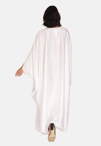 Lange witte satijnen kaftan met brede mouwen en een oversized pasvorm, met een ronde halslijn, vloeiende silhouet en subtiele glans.