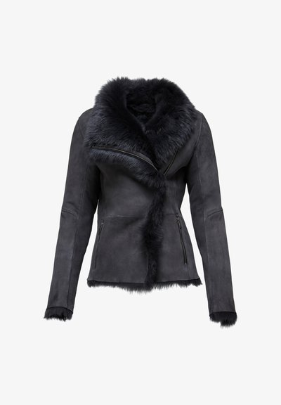 Zwarte suede jas met een faux-fur kraag, asymmetrische rits aan de voorkant, lange mouwen en zijzakken met rits. Zachte textuur en strakke ontwerp.