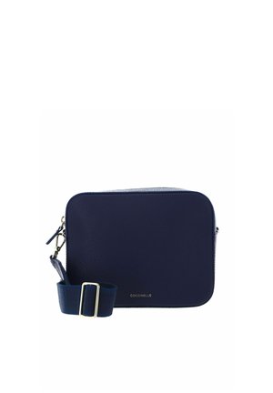 Sac bandoulière rectangulaire en cuir bleu marine avec sangle réglable et ferrures dorées, petit nom de marque embossé à l’avant.