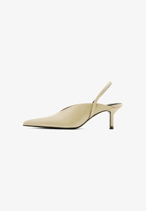 Beżowe buty typu slingback z ostrym noskiem, niskim obcasem szpilką i cienkim regulowanym paskiem wokół pięty.