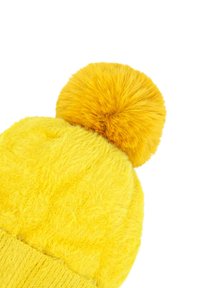 Beanie giallo lavorato a maglia con una texture soffice, sormontato da un pompon peloso coordinato. Il cappello presenta un bordo a coste nella parte inferiore.