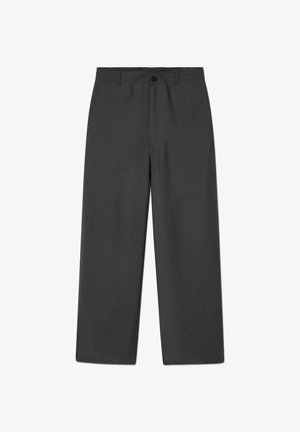 Pilkos spalvos, platėjančios kelnės, pagamintos iš lengvos medžiagos. Turi elastingą juosmenį ir priekyje sagomis užsegamą uždarymą, su lygiu paviršiumi.