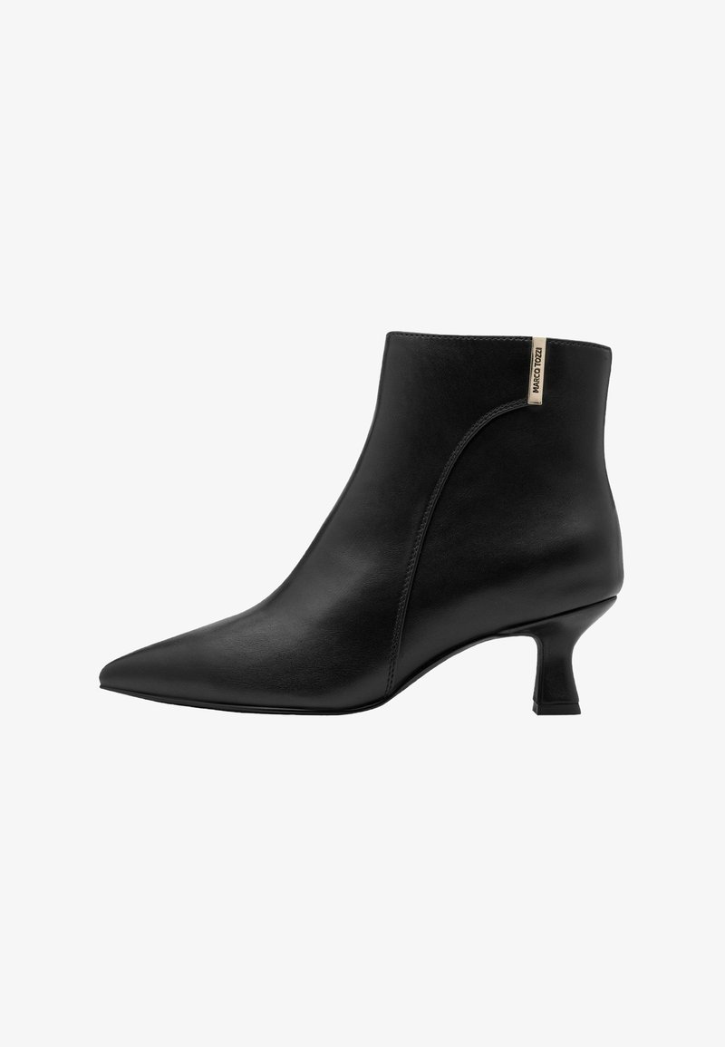 Bottine en cuir noir à bout pointu, talon moyen incurvé et petite étiquette beige près du bord supérieur sur le côté extérieur.