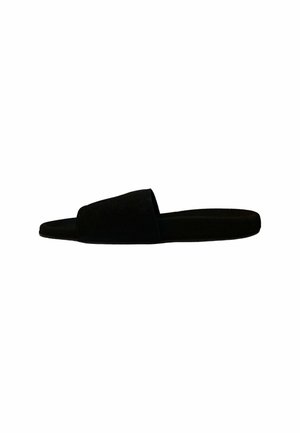 Sandalia deslizante de ante negro con punta abierta y suela plana, que presenta un diseño minimalista y una construcción sin costuras.