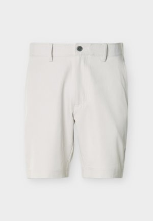 Lys beige kne-lange shorts med knappelukking, beltehemper og sidelommer, lagt flatt på hvit bakgrunn.