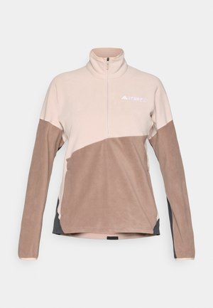 Fleecepullover i ljusrosa och bruna färgblock, hög krage, halv dragkedja, med broderad logotyp på bröstet. Mjuk textur.