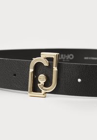 Cintura in pelle nera con fibbia rettangolare in tono oro e un accento circolare, dotata di diversi fori di regolazione lungo la cinghia.