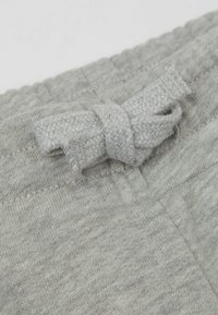 Graue Stoffshorts mit einer strukturierten Oberfläche, ausgestattet mit einem gebundenen Kordelzug am Bündchen für einen verstellbaren Sitz und Komfort.