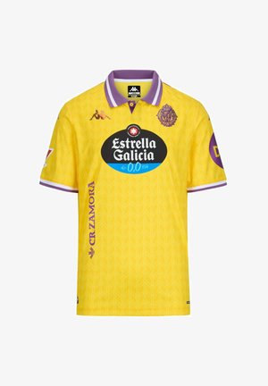 Maillot jaune à manches courtes avec un motif texturé en forme de feuilles. Il présente des accents violets, un col et des logos dont "Estrella Galicia".