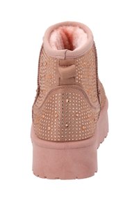 Botín rosa con un upper texturizado, adornado con tachuelas metálicas. Forro suave, cuello acolchado y una suela gruesa para mayor soporte.