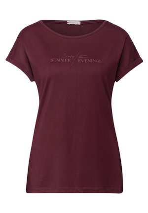 T-shirt bordeaux avec un col rond, des manches courtes retroussées et le texte "Soirées d'été confortables" imprimé en couleur claire sur la poitrine.