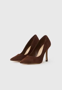 Brune suède høyhælte pumps med spiss tå og slank stiletthæl. Glatt tekstur og minimalistisch design.