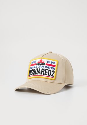 Beige baseball cap with structured design. Features a bold, embroidered patch with "DSQUARED2" and colorful accents.