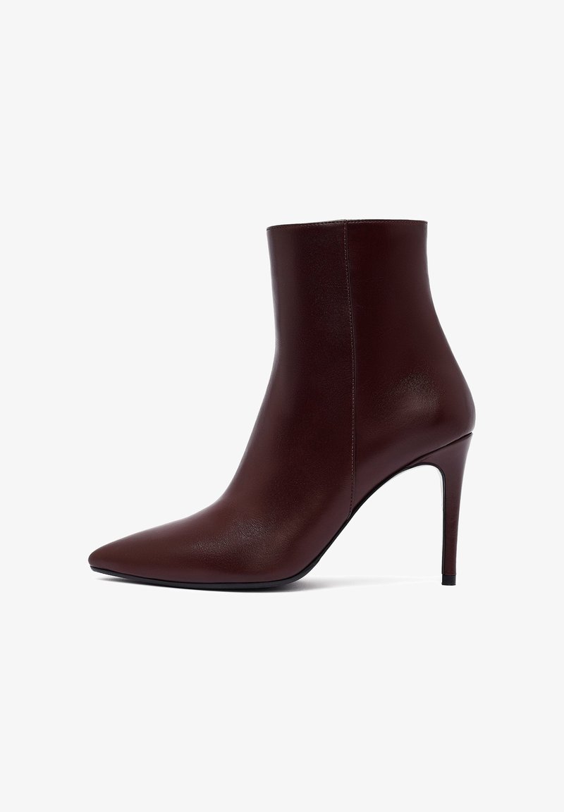 Bottine bordeaux en cuir lisse, dotée d'un bout pointu et d'un talon aiguille haut. Design simple sans embellissements visibles.