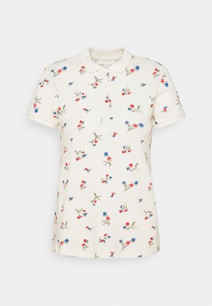 Polo blanc à manches courtes avec un petit imprimé floral rouge, bleu et rose dispersé uniformément sur le tissu.