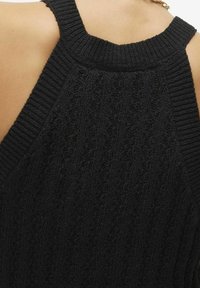 Czarny dzianinowy bezrękawnik z prążkowanym dekoltem i teksturowanym wzorem, z widocznymi detalami szwów oraz otwartym tyłem.