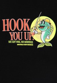 Čierne tričko s kreslenou rybou, ktorá drží rybársku prut, s nápisom "HOOK YOU UP!" tučnými červenými písmenami a ďalším textom v zelenej farbe.