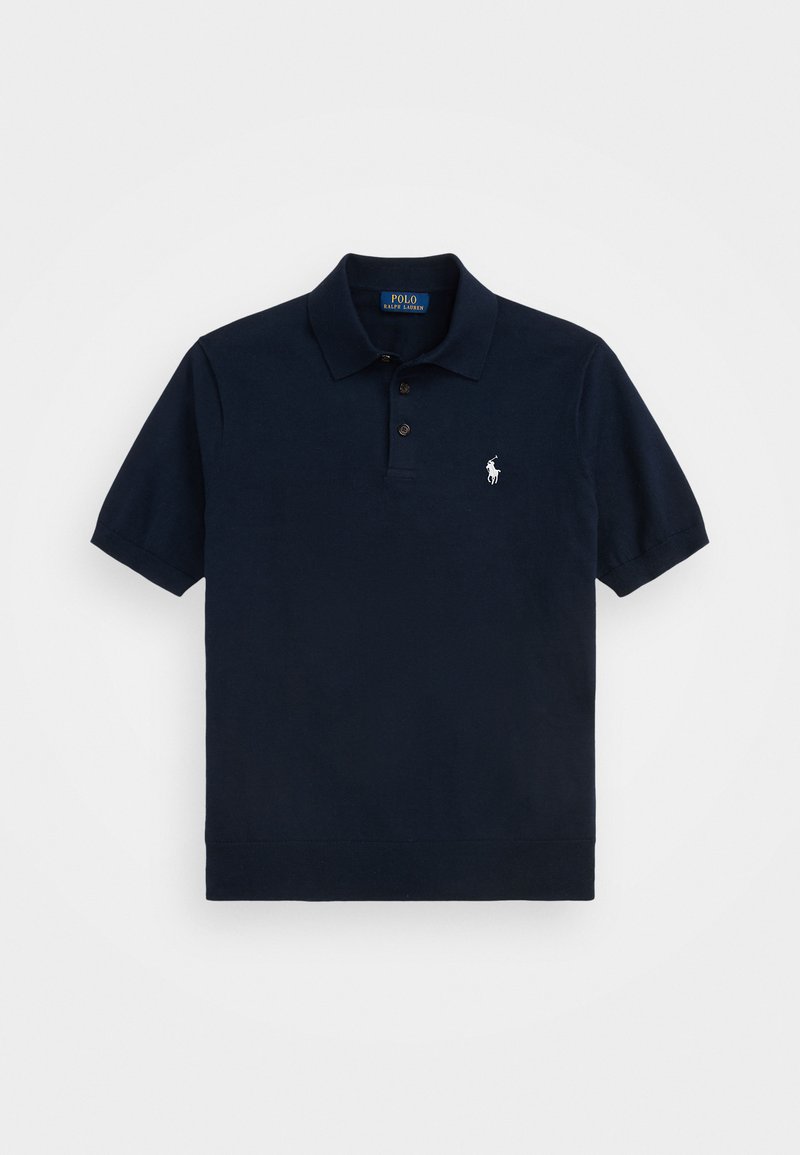 Naktinės mėlynos spalvos polo marškiniai pagaminti iš medvilnės. Turėti trijų mygtukų apykaklę, trumpas rankoves ir mažą siuvinėtą logotipą kairėje krūtinės pusėje.