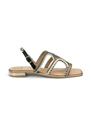Flat sandal with multi-straps in black and white, metallic accents, beading detail, and a small clear block heel. Textured interior.