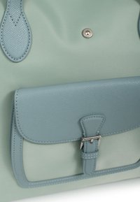 Borsa a mano verde chiaro, con accenti in pelle blu testurizzata, chiusura a scatto e forma strutturata con manici superiori.