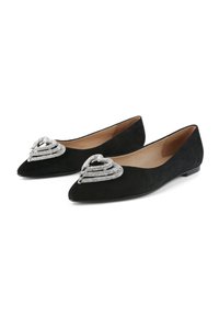 Ballerines noires en daim avec un design à bout pointu et un ornement décoratif en forme de cœur argenté orné de multiples accents ressemblant à des cristaux.