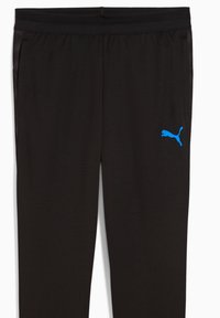 Zwarte sportbroek met een mesh-structuur, met een blauwe Puma-logo op de linkerdij en zijzakken met contrasterende zwarte accenten.