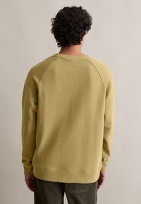 Mosterdgele sweatshirt met ribgebreide halslijn en manchetten, met een ontspannen pasvorm en schoudernaden ontworpen voor comfort.