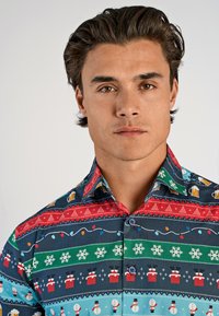 Korte mouwen overhemd met kleurrijke feestelijke patronen, waaronder sneeuwpoppen, kerstbomen en feestelijke lichten, op een blauwe achtergrond.