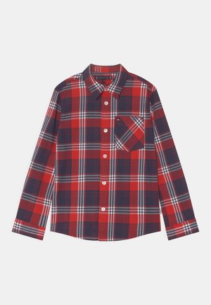 Chemise à boutons à carreaux rouge et marine avec des manches longues, dotée d'une poche poitrine et de lignes blanches contrastées dans le motif. Tissu en mélange de coton.