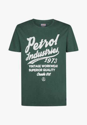 Camiseta de algodón verde con mangas cortas, con texto retro en blanco: "Petrol Industries 1973 Vintage Workwear Calidad Superior Crudo".