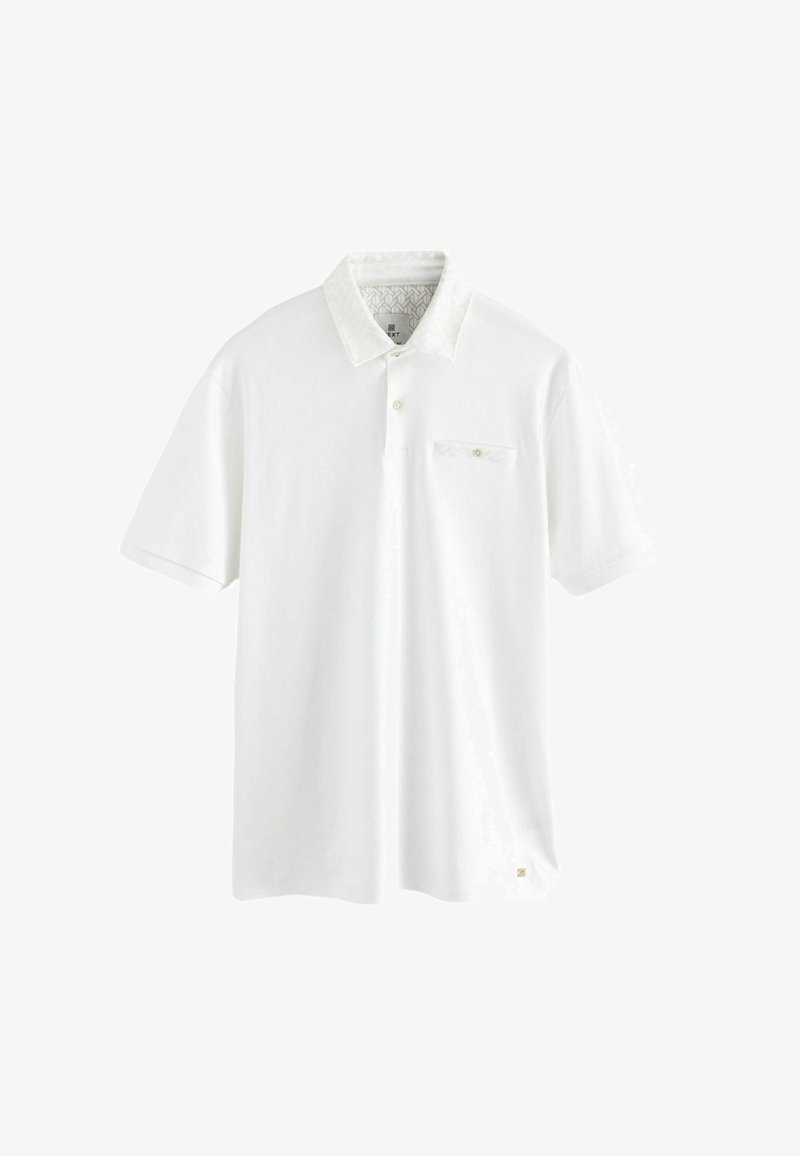 Weißes Poloshirt aus Baumwolle mit gemustertem Kragen. Verfügt über eine Knopfleiste und eine kleine Brusttasche mit einem Knopfdetail.