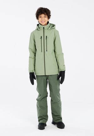 Außenjacke und Hose in Hellgrün, aus wasserdichtem Material. Merkmale sind eine Kapuze, Reißverschlusstaschen und schwarze Handschuhe. Texturierte Oberfläche.