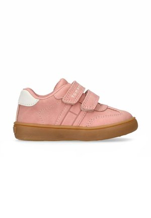Baskets en suède rose avec un accent de talon blanc, deux bandes velcro et une semelle en caoutchouc à relief. Logo de la marque sur les bandes et les rayures latérales.
